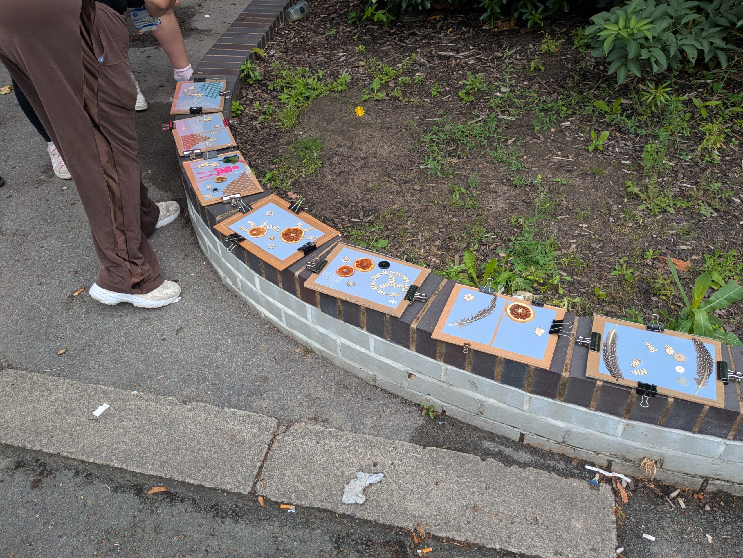 Artwork by young carers laid out on a park wall.