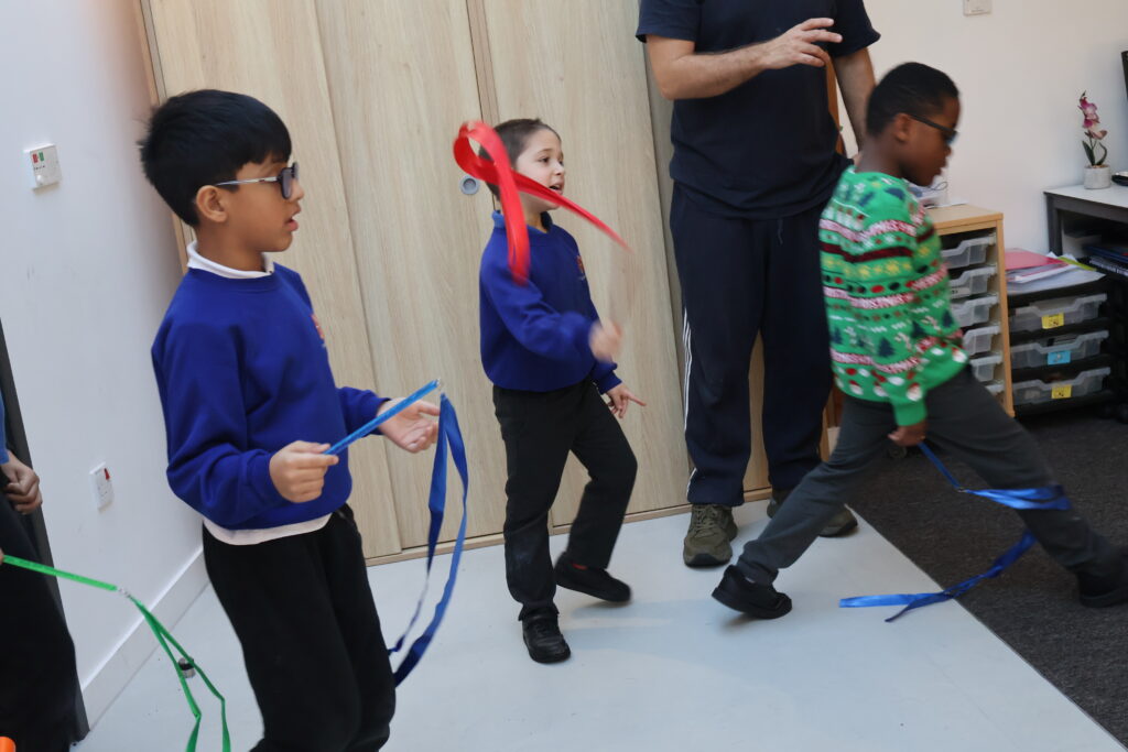 SEND students explore reading and stories through dance. They hold ribbons and dance in a room.