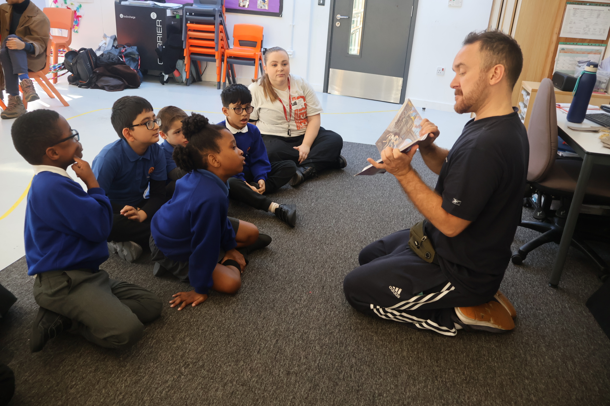 A Create artist shows SEND children  a story book with pictures, to explore stories through dance on an our:stories project.
