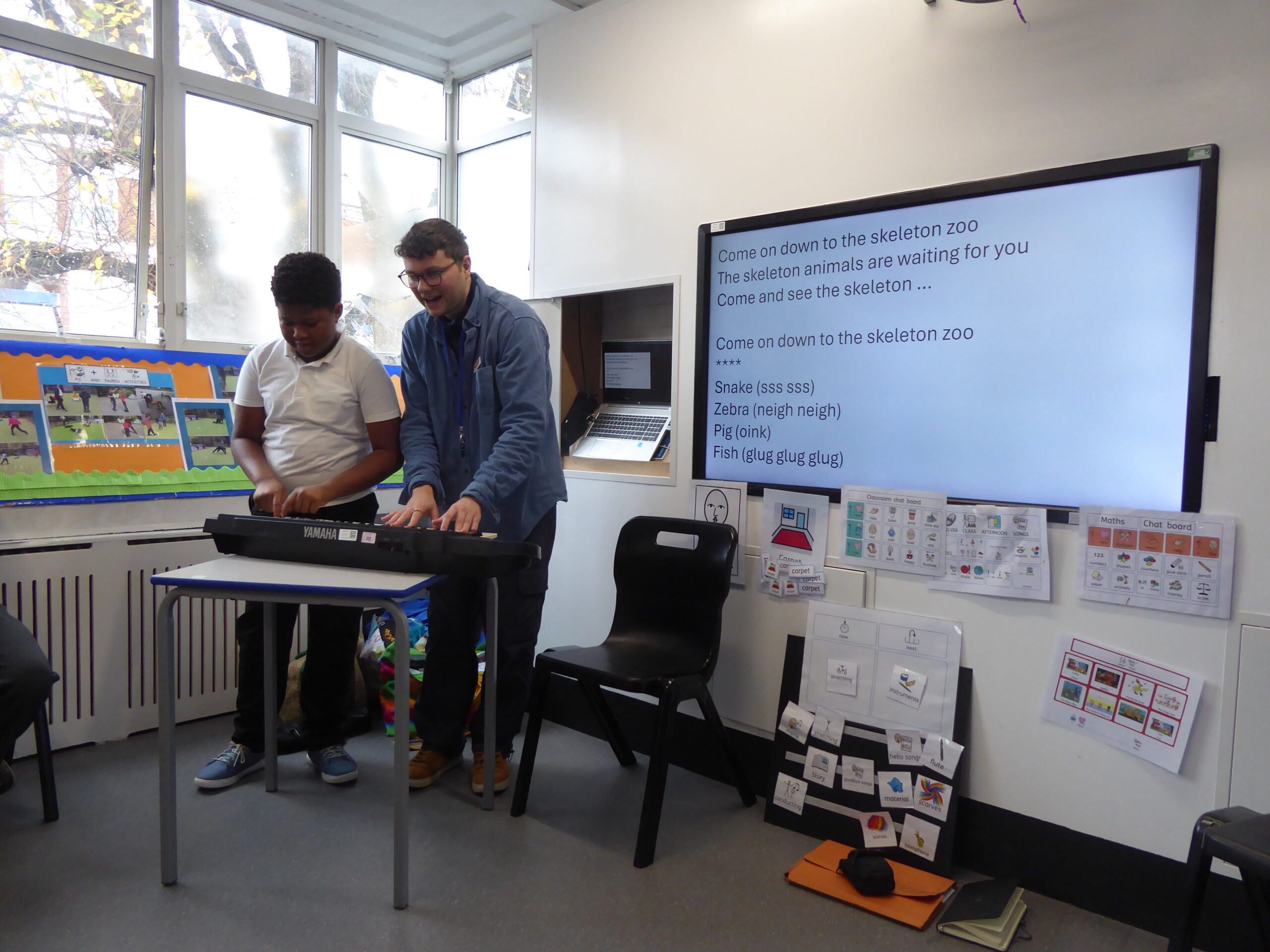 SEND young person with Create artist, playing a keyboard in a school setting, exploring reading and stories through music.