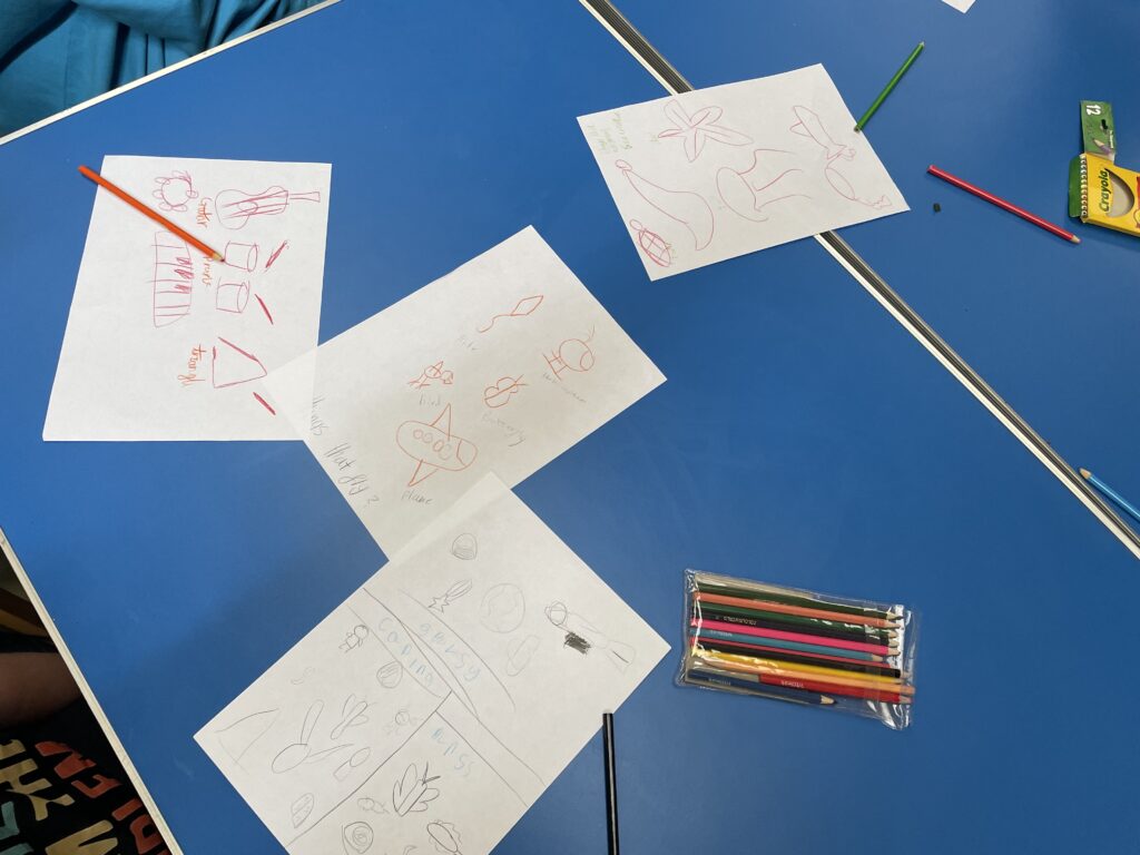 Drawings by young carers on a table.