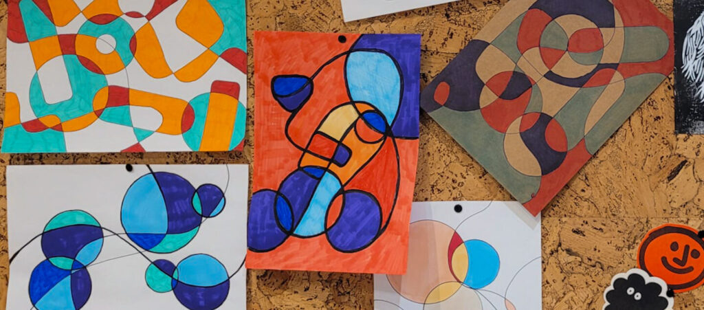 Artwork on a brown pinboard
