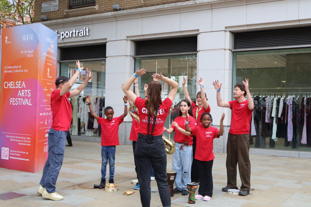 Young carers performing on the street at Chelsea Arts Festival 2026.
